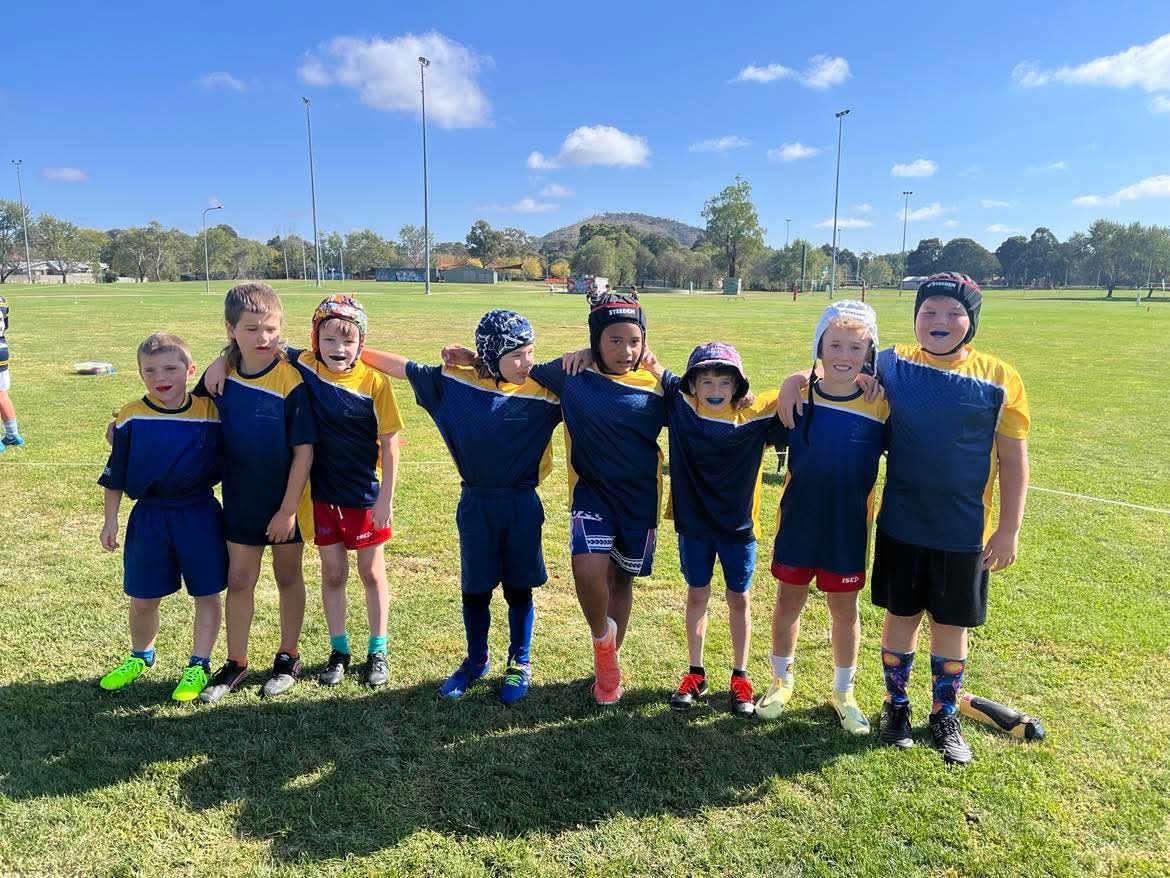 Photo of eight students wearing Theodore Primary Sports Jerseys and head gear for football